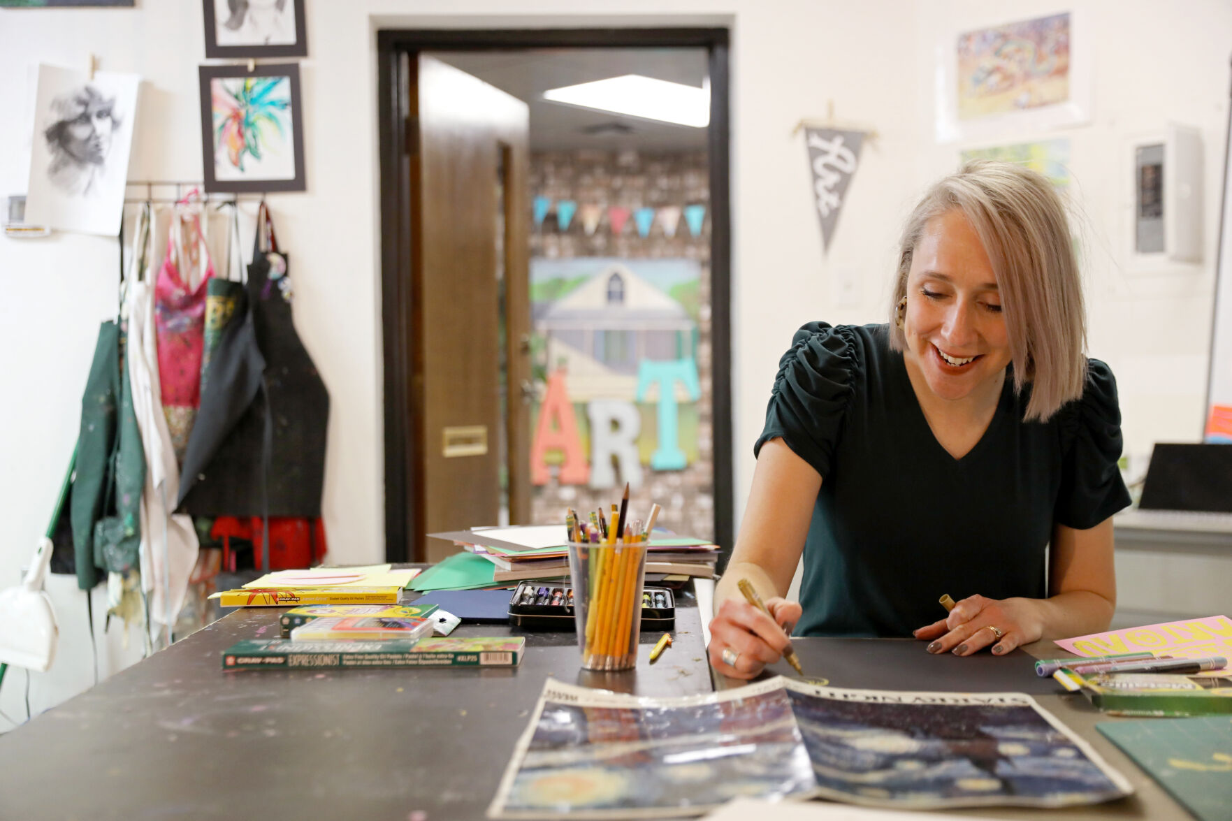Wendi Jensen sits at a table at Art Underground